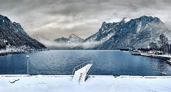 gray dock coated with snow in front of sea thumbnail