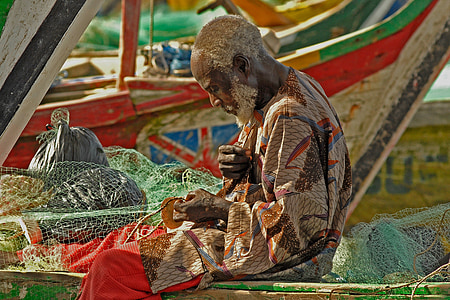fisher man knitting the net on the boat thumbnail