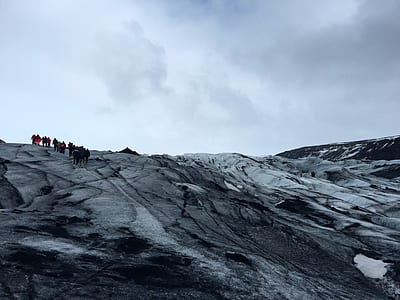 people in mountain under cloudy sky thumbnail