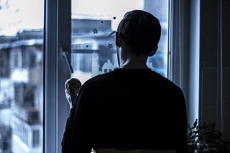 Man Looking Outside Near Clear Glass Window thumbnail
