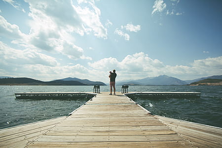 Person Standing on Brown Wooden Dock Under Clue Sky during Daytime thumbnail