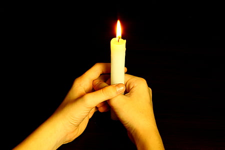 person holding white candle thumbnail