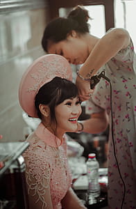 Woman in Pink Collared Blouse Smiling While Sitting thumbnail