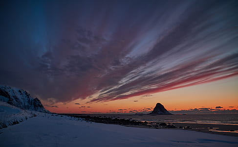 snow-covered field under brown and gray sky at dusk thumbnail