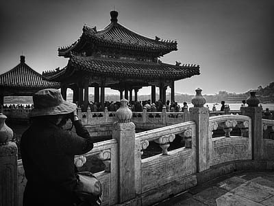 woman taking a photo of a temple during daytime thumbnail