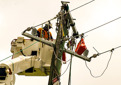man repairing electric post during daytime thumbnail