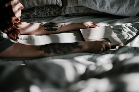 woman holding open book page on white textile thumbnail