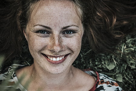 close up photo of smiling woman wearing white floral shirt thumbnail