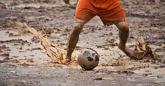 man wearing orange short playing soccer thumbnail