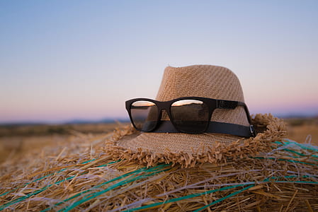 black framed wayfarer-style sunglasses on brown hat thumbnail