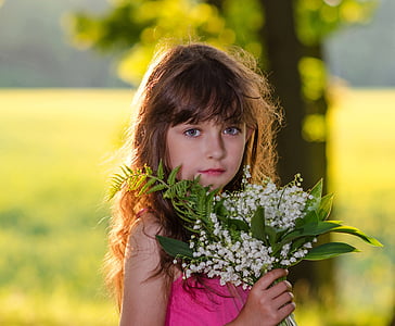 girl's in pink top holding white flowers thumbnail