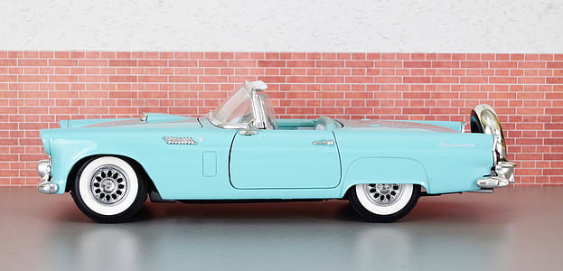 teal classic coupe parked beside red wall thumbnail