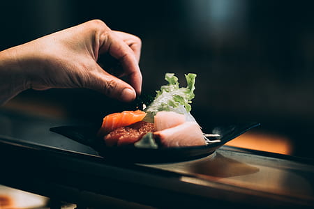 person holding sushi on plate thumbnail