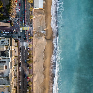 aerial photography of seashore and asphalt road during daytime thumbnail