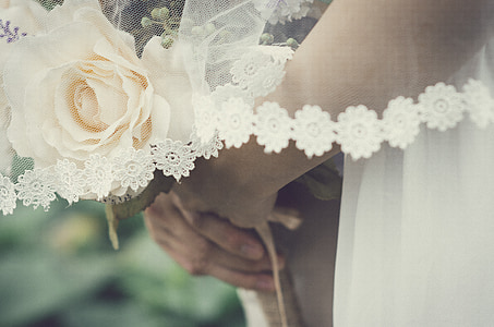 close-up photography of woman holding white rose flower bouquet thumbnail