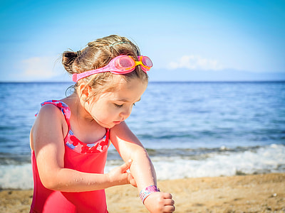 girl on the beach looking at her elbow thumbnail