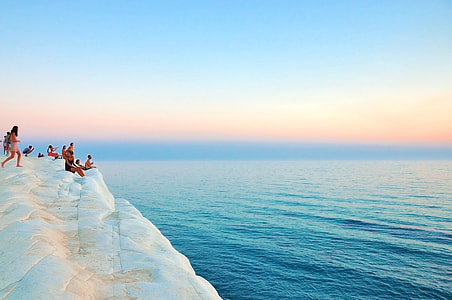 people at the cliff of the island during day thumbnail