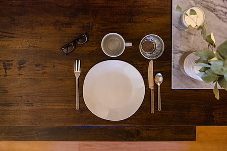 flat lay photography of white plate between flatware on table thumbnail