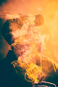 man wearing fitted cap covered white and orange cigarette smoke photo thumbnail