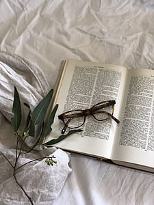 eyeglasses with tortoiseshell frame on white book thumbnail