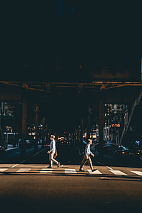 two man crossing on pedestrian lane during nighttime thumbnail