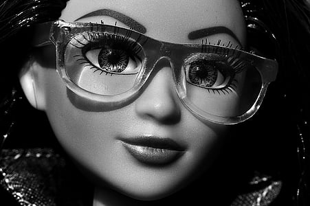 grayscale photography of girl doll wearing eyeglasses thumbnail