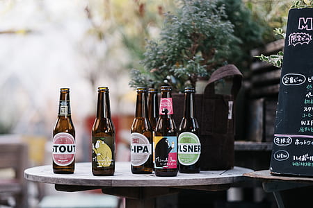 assorted labeled bottles on table near bag and menu thumbnail