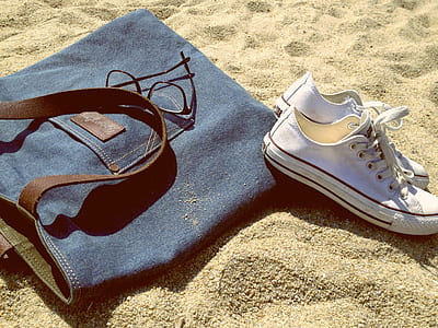 blue denim bag beside white low-top sneakers thumbnail