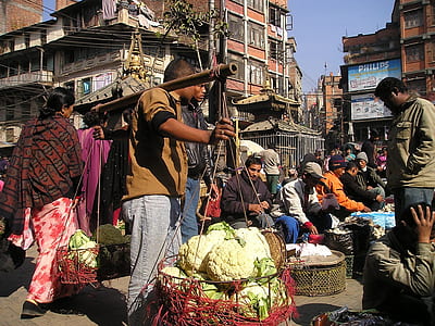 crowd of people selling vegetable near the brown concrete building at daytime thumbnail