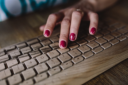 Closeup of female hands typing text on a wireless wooden keyboard thumbnail