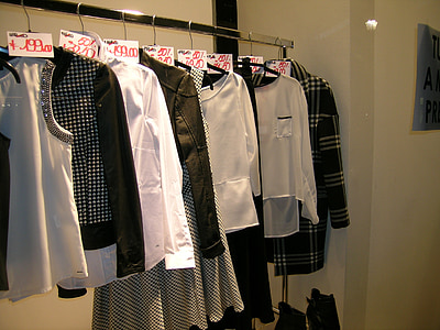 assorted apparels hanged on stainless steel clothes rack in room thumbnail