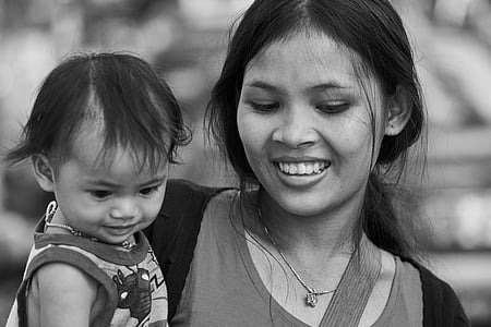 grayscale photography of woman carrying child thumbnail