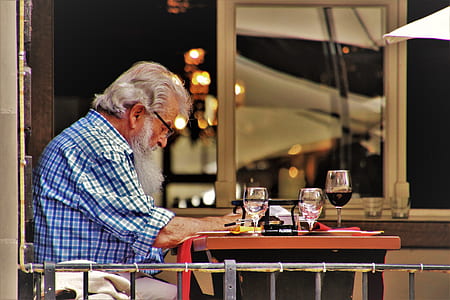 man in blue dress shirt reading inside restaurant thumbnail