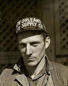 Black and White Photo of Man Wearing New Orleans Supply Hat thumbnail