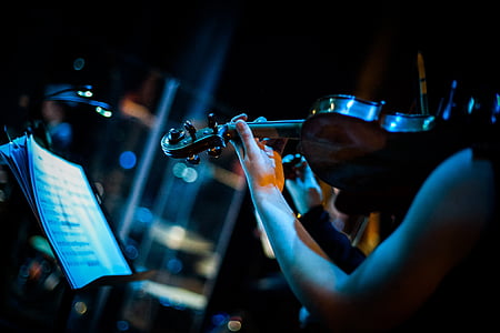 low light photography of person playing violin thumbnail