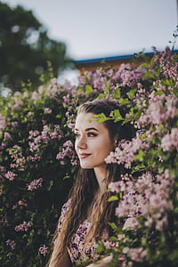 woman sitting between pink flowers thumbnail