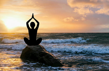 person sitting on rock near wave thumbnail