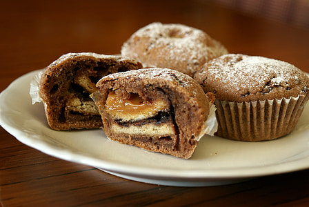 sliced muffin with fillings beside two muffins on white plate thumbnail