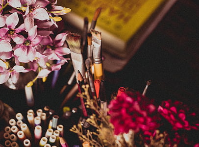 assorted-color pens near pink petaled flowers thumbnail