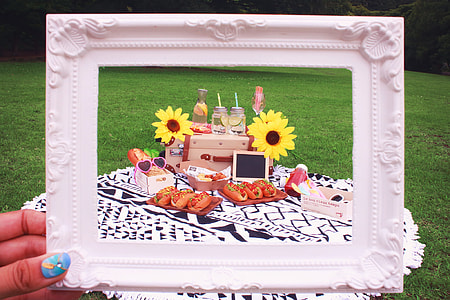 person holding rectangular white photo frame in front of varieties of foods and sandwiches thumbnail