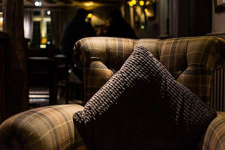black throw pillow on brown couch thumbnail