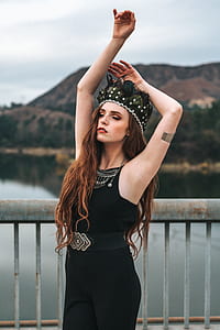 woman standing near body of water while raising her hands thumbnail