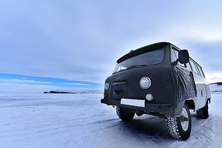black and white van on snow-covered field during daytime thumbnail