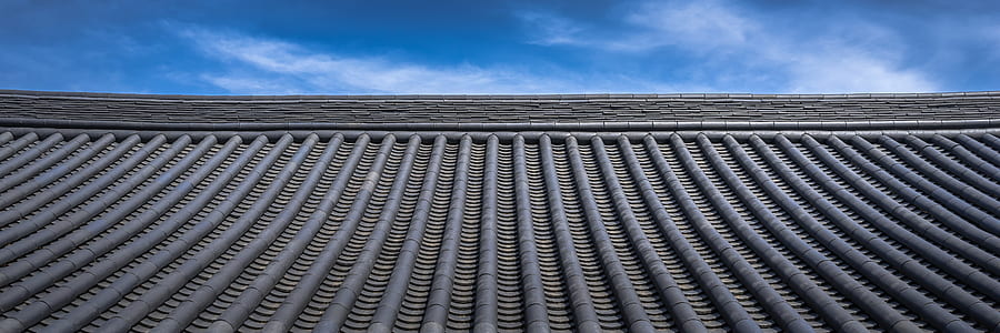 low-angle photography of roof under white clouds and blue sky thumbnail