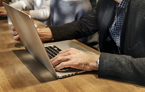 person in black blazer using silver laptop computer thumbnail