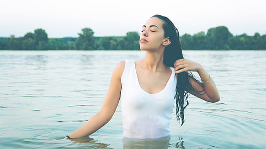 woman bathing in lake during daytime thumbnail