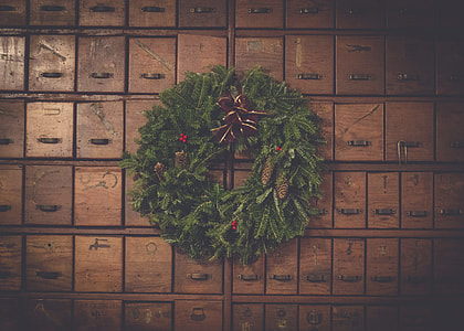 green garland wreath mounted on brown wooden cube drawers thumbnail