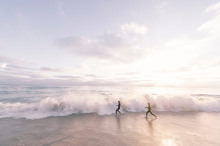 two persons running on seashore thumbnail