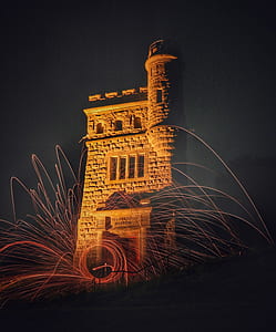 steel wool photography of fireworks in front on brown concrete building thumbnail