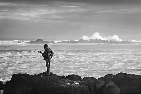 person near body of water in grayscale photography thumbnail